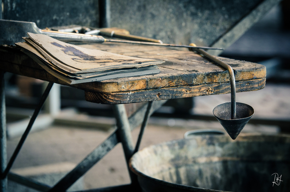 Here is a closer look at some of his tools: the papers that he wets and uses to smooth the glass;&nbsp;a funnel blower to make for fine adjustments in blown products;&nbsp;a tool for defining edges and making the brake-off point;&nbsp;a pail of water;&nbsp;etc.